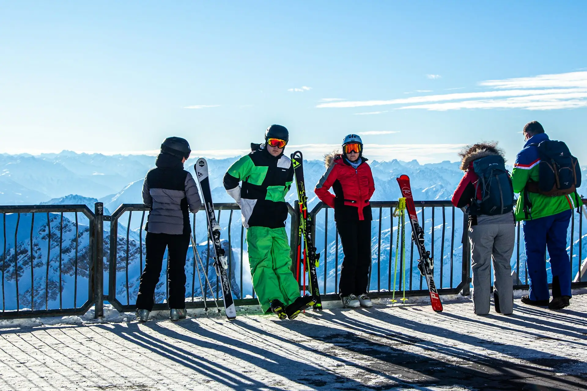 winter sports destinations in Europe A group of skiers and snowboarders enjoying the view of snowy mountains, showcasing popular winter sports destinations in Europe