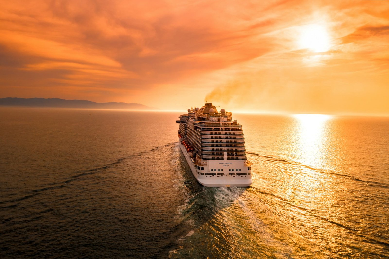 A large cruise ship sailing on the open sea at sunset, symbolizing the beginning of a Multi-City Trip to Europe.