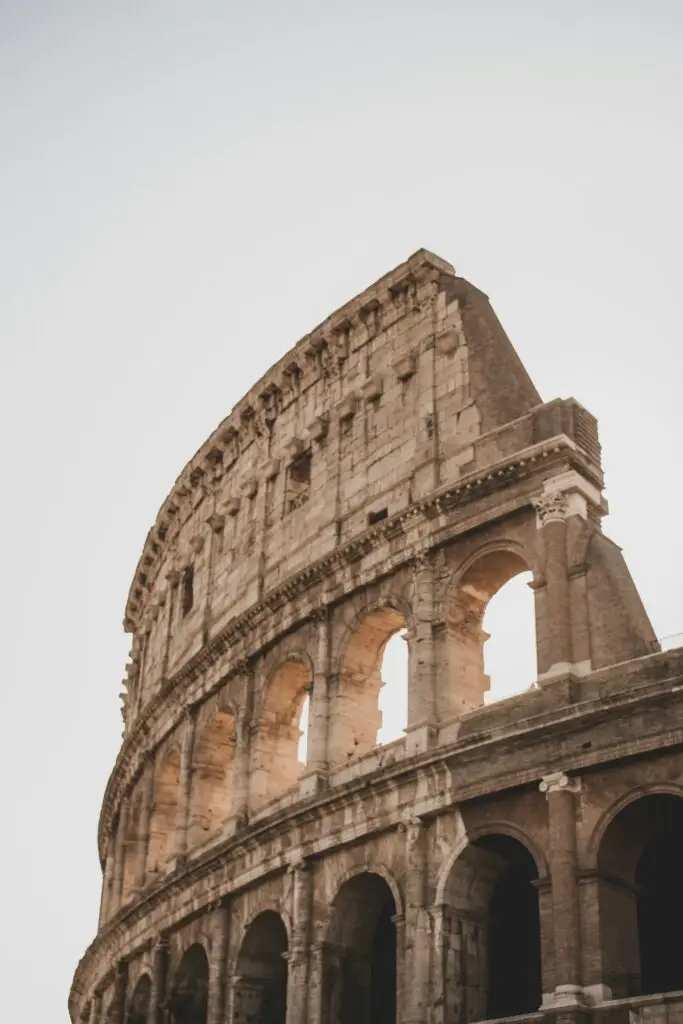 1 day in Rome: A stunning view of the Colosseum's ancient arches basking in the soft evening light, capturing the timeless beauty and grandeur of this iconic Roman landmark.