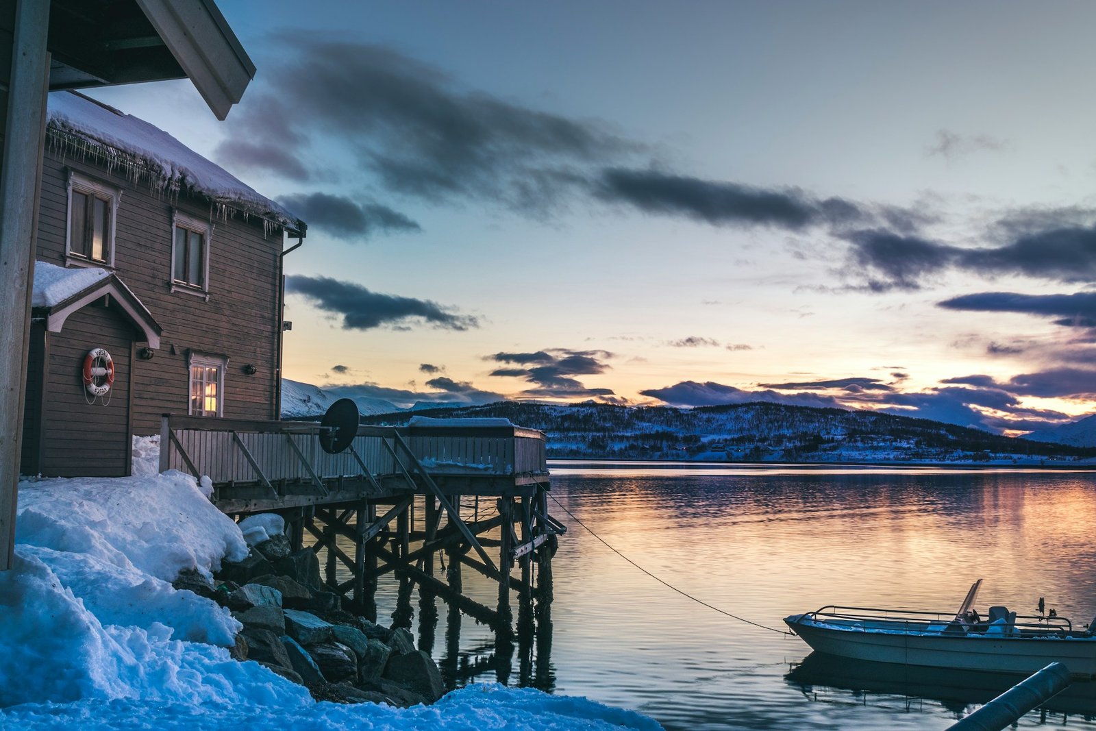 A cosy cabin by the water at sunset in Tromsø, one of the best cities to visit in Norway.