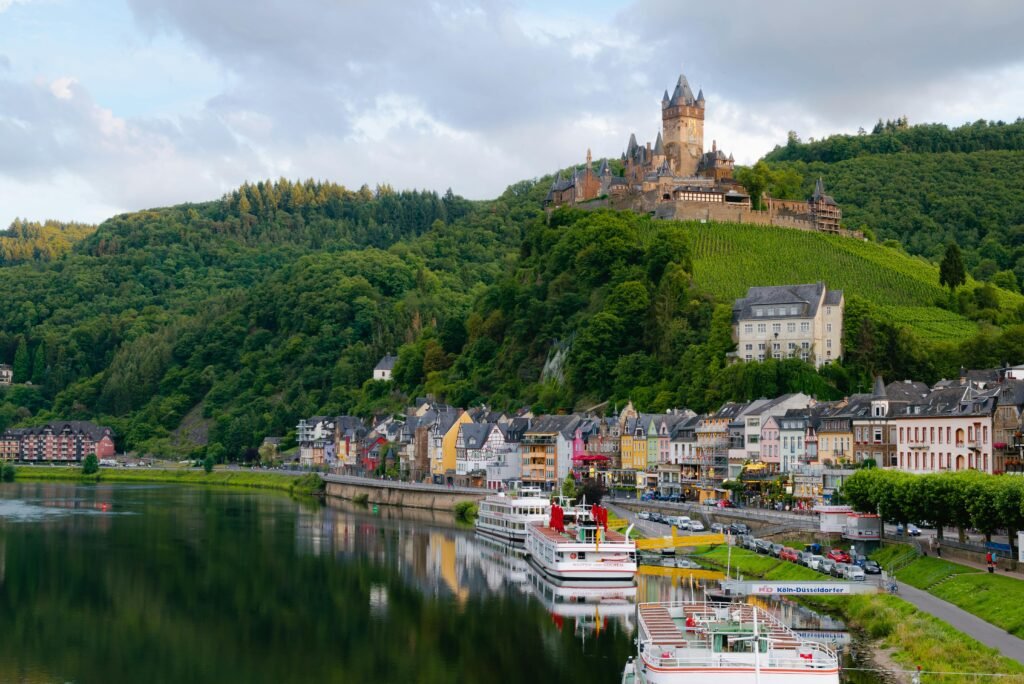 Best Time to Visit Germany? Skip Summer! (Do This) The best time to visit Germany is during spring or summer, as seen in this beautiful view of Cochem Castle overlooking the Moselle River, with colourful houses and green vineyards.